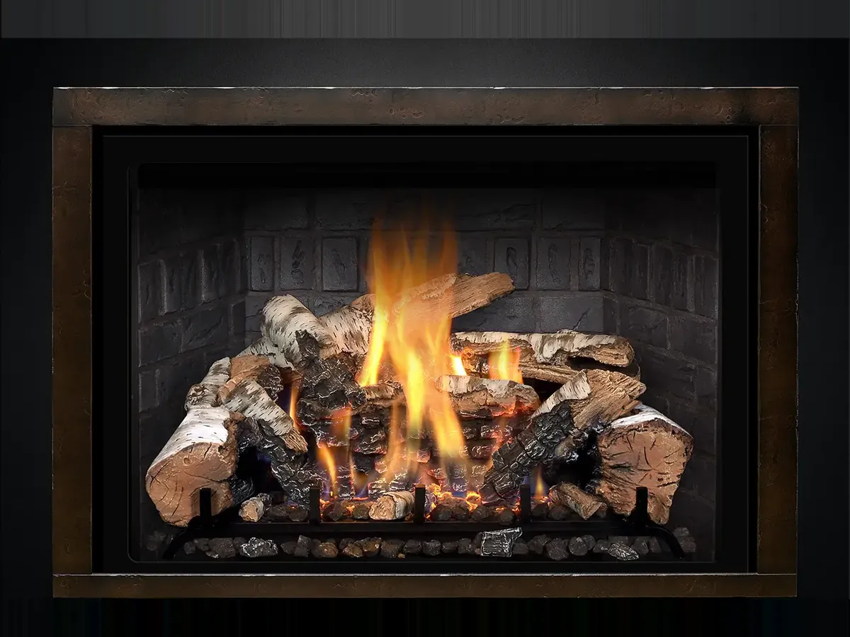 A Mendota gas insert with a birch log fire burning inside a bronze frame